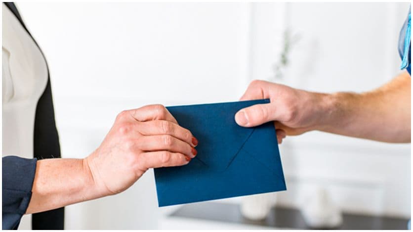 Two people exchanging an envelope 