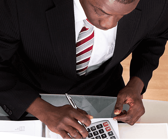 Man in suit using a calculator